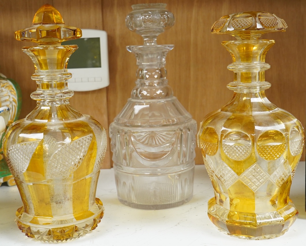 Two late 19th century Bohemian amber flashed decanters and another decanter, tallest 26cm